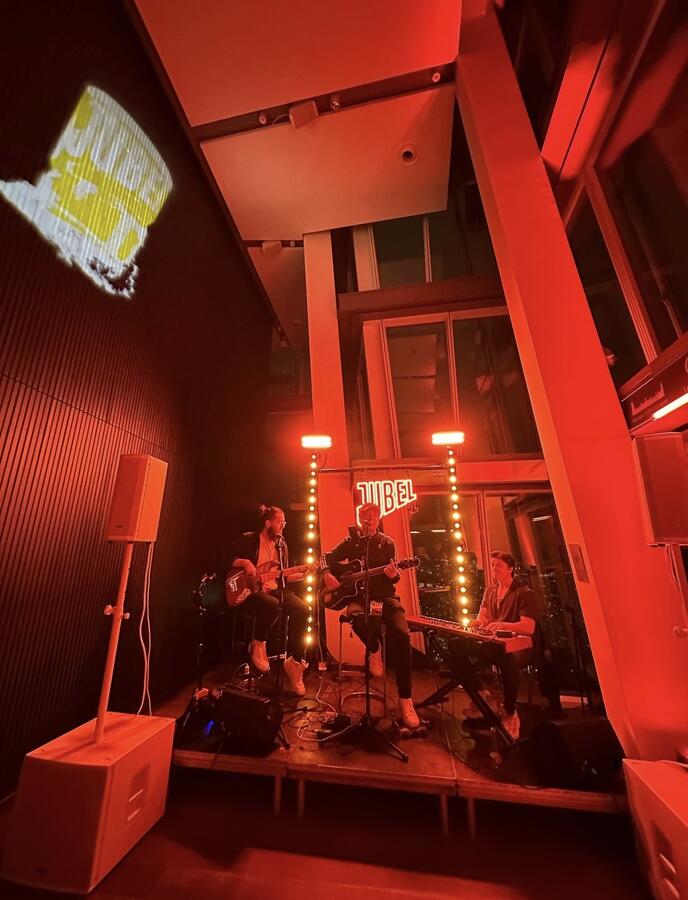 Live band performing with logo projection at The Shard