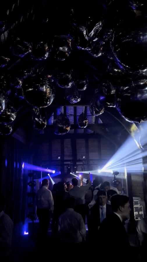 Silver balloons with blue beam lighting at private party